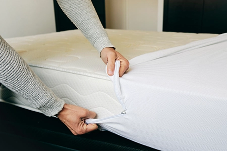 Person applying a mattress cover to a bed - Allied Pest Control in Memphis TN